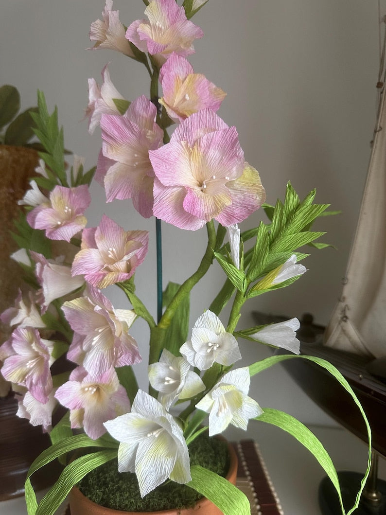 Gladiolus flowers made of realistic crepe paper in a terracotta pot.
