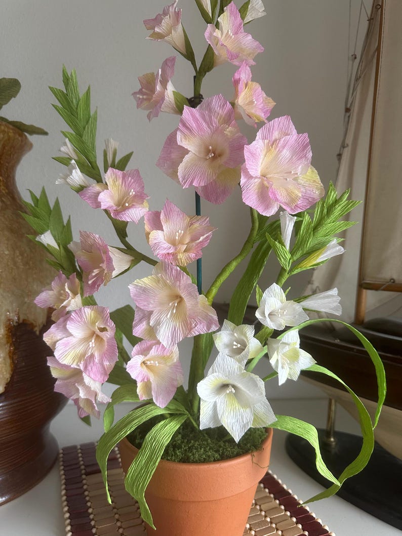 Gladiolus flowers made of realistic crepe paper in a terracotta pot.