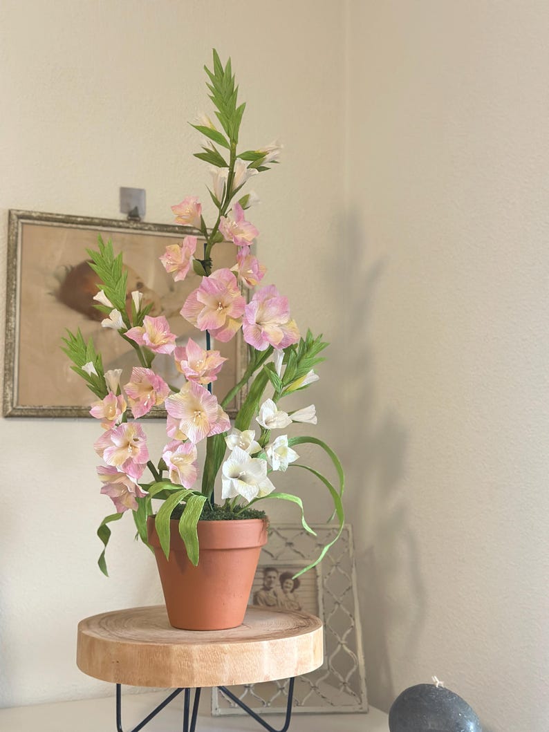 Gladiolus flowers made of realistic crepe paper in a terracotta pot.